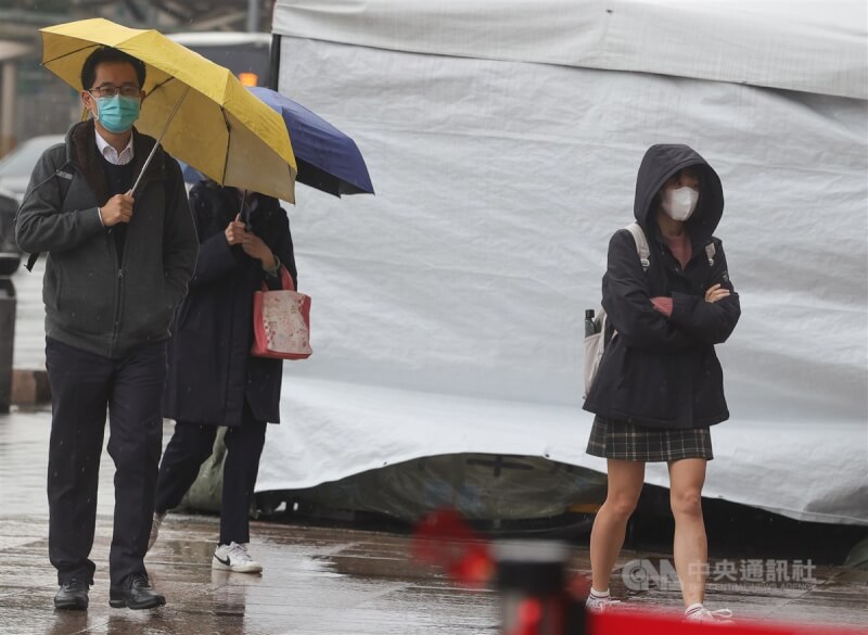 圖為台北市中正區下起陣雨，街頭民眾撐傘或戴上帽子遮擋雨勢。（中央社檔案照片）