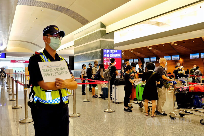 圖為航警局派員在桃園國際機場舉牌宣導，提醒民眾慎防海外打工詐騙。（中央社檔案照片）