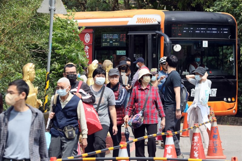 圖為民眾戴上口罩搭乘公車前往台北富德公墓掃墓祭祖。（中央社檔案照片）