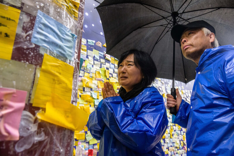 韓國梨泰院踩踏悲劇發生後，李鍾哲（右）與趙美恩夫妻5日在事發巷弄內悼念罹難的愛子。（法新社）