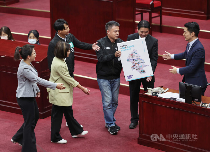 台北市長蔣萬安（右）13日首度赴台北市議會施政報告，北市議會民眾黨團送上前副市長黃珊珊的市政白皮書。中央社記者王飛華攝  112年4月13日