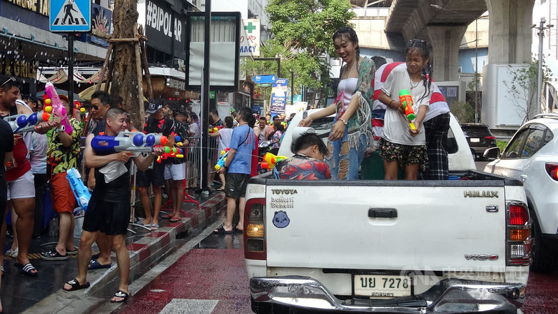 擺脫COVID-19疫情陰影，俗稱潑水節的泰國新年宋干節慶祝活動疫後首度全面回歸。圖為曼谷席隆區路邊民眾和車上的民眾拿水槍互射。中央社記者呂欣憓曼谷攝 112年4月13日