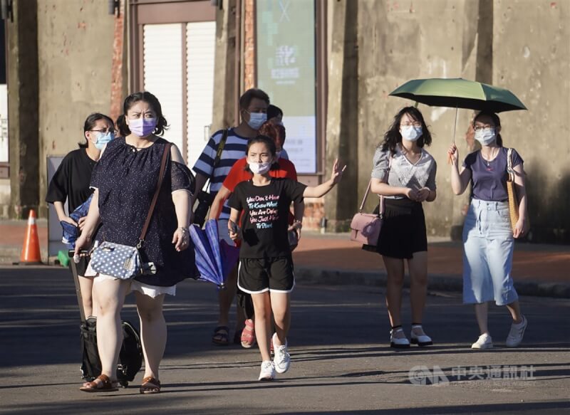 中央氣象局14日發布台東地區高溫黃色燈號，氣象局觀測，台東縣大武氣溫已達攝氏35.5度。圖為高雄市鹽埕區街頭，民眾撐陽傘遮擋毒辣陽光。（中央社檔案照片）