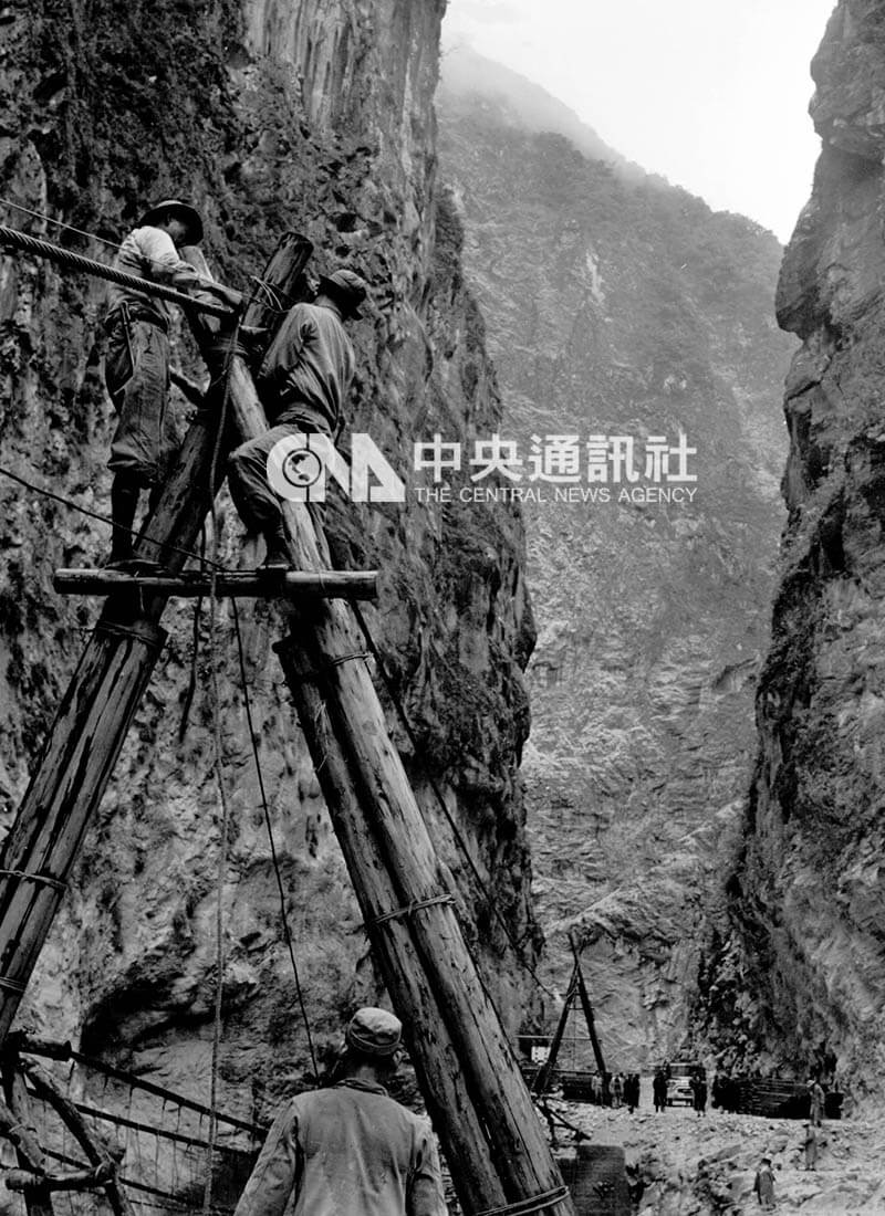 中橫施工期間進行無數個艱鉅危險的工程，圖為1958年工人在高聳的山壁間，通過一個深谷，準備架起一座橋梁。（中央社檔案照片）