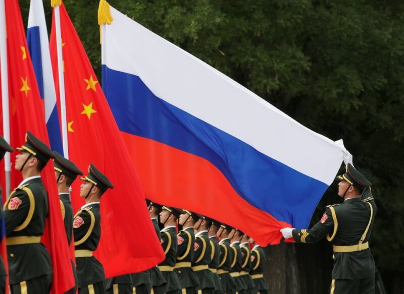 中國國務委員兼外長秦剛13日在烏茲別克會見俄羅斯外長拉夫羅夫，雙方再對俄烏戰爭交換意見。圖為2018年一名中國軍官在蒲亭歡迎儀式前整理俄羅斯國旗。（路透社）