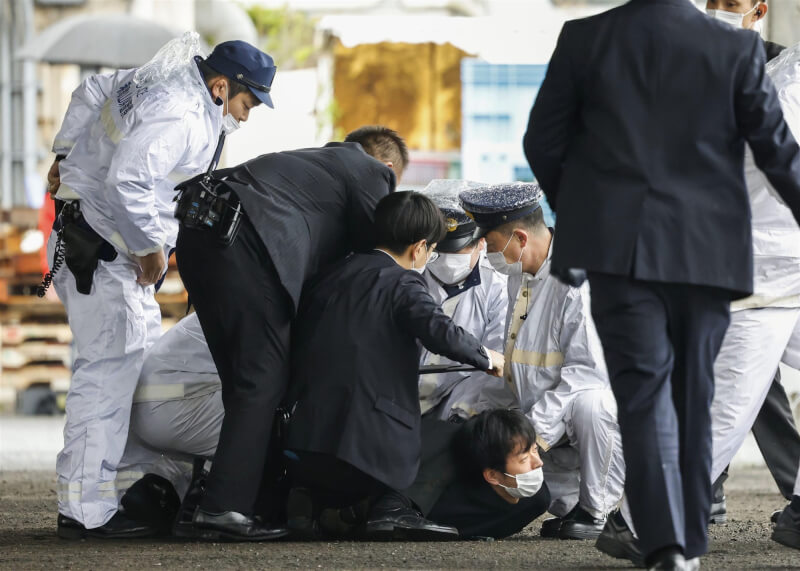 日本首相岸田文雄15日輔選時遭人丟擲爆裂物，男性犯嫌（中下）當場被逮。（共同社）