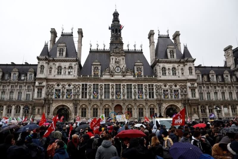 法國憲法法院14日批准總統馬克宏受爭議年金改革案的主要項目，即退休年齡由62歲提高至64歲。圖為群眾到巴黎市政廳外示威抗議。（路透社）