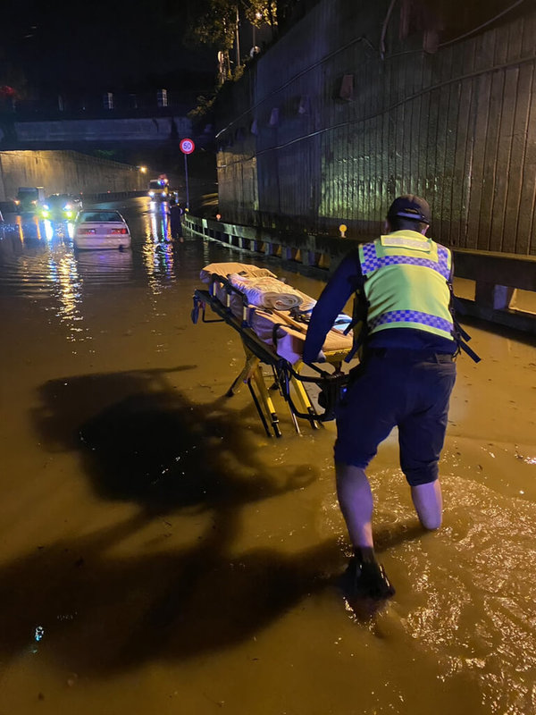 豪雨來襲，苗栗縣消防局20日表示，苗栗市國華地下道積水嚴重時逼近20公分，一度暫時封閉，有休旅車冒險涉水通過時受困，車上人員腹痛，消防人員冒雨推擔架進入，協助駕駛送醫。（苗栗縣消防局提供）中央社記者管瑞平傳真  112年4月20日