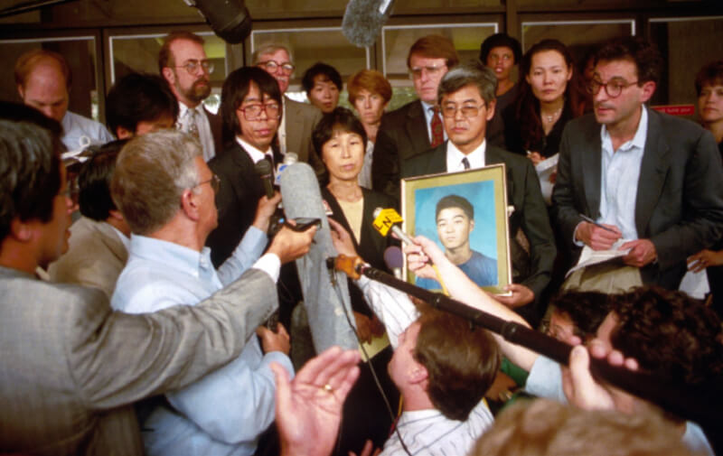 1994年,服部剛丈的父母捧著兒子的遺照,於路易斯安那州的地方法院外,接受媒體提問。(美聯社)
