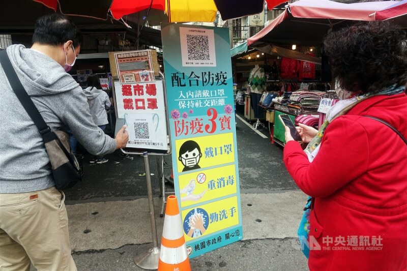 民眾2022年1月赴桃園南門市場,入場前落實指揮中心一再呼籲的「實聯制登記」。(中央社檔案照片)