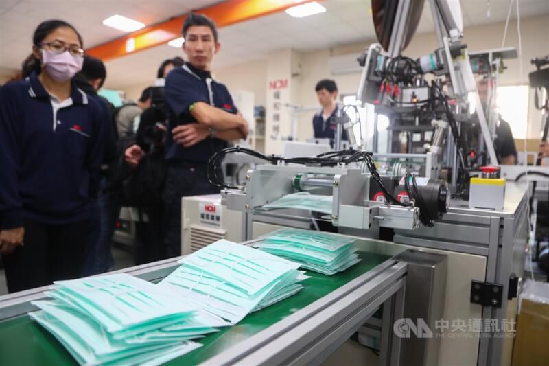 因應疫情,新北市鶯歌區權和機械公司加開口罩設備生產新機組提升產能,工作人員檢視口罩生產線的運作情形。(中央社檔案照片)
