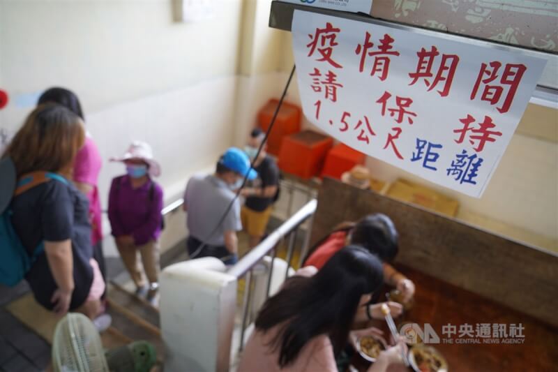 指揮中心2020年5月公布「防疫新生活運動」4大要點,包括保持社交距離、量體溫、戴口罩、實名制等。台北市北投市場內店家張貼告示,提醒排隊民眾保持社交安全距離。(中央社檔案照片)