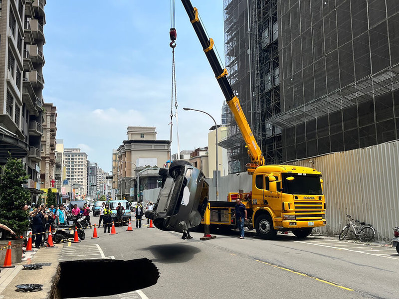 新竹縣竹北市一處建案附近道路曾多次坍塌，27日上午鄰近的莊敬六街又塌陷，停放停車格內的特斯拉轎車墜落坑洞；縣府表示，已勒令施工單位立即停工，後續徹底調查，釐清坍塌原因。（新竹縣議員蔡蕥鍹提供）中央社記者管瑞平傳真  112年4月27日