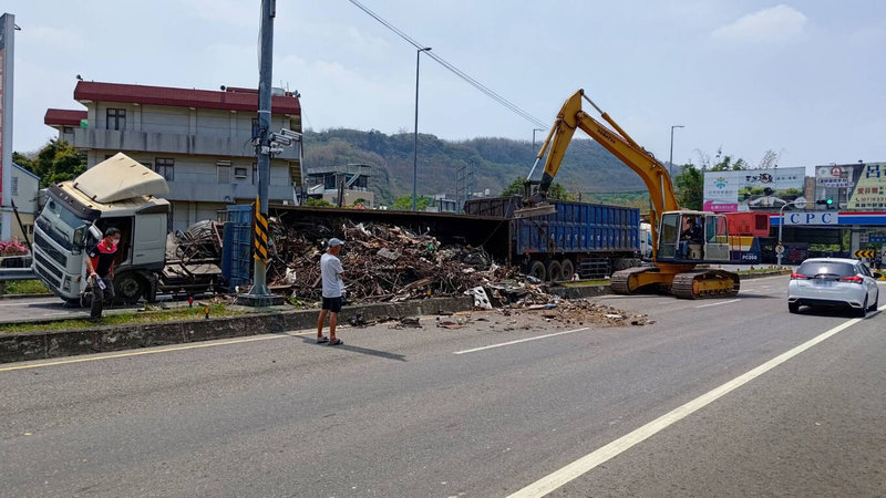 林姓男子27日駕駛聯結車行經高雄市阿蓮區峰山路右轉時疑不熟路況翻覆，車上滿載廢五金散落地面，一度影響交通。（高雄市湖內警分局提供）中央社記者洪學廣傳真  112年4月27日