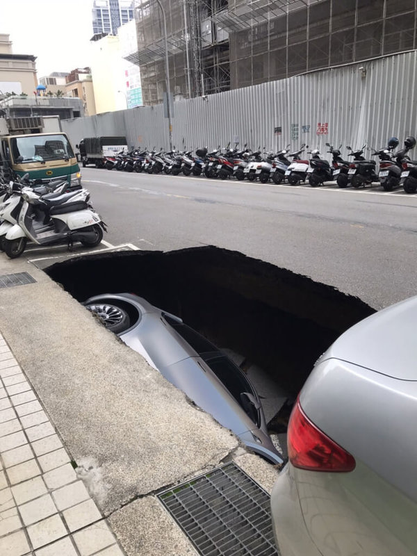 新竹縣竹北市莊敬六街27日上午發生路基坍塌，一輛停放路邊的特斯拉轎車直接掉落大坑洞。（民眾提供）中央社記者管瑞平傳真 112年4月27日