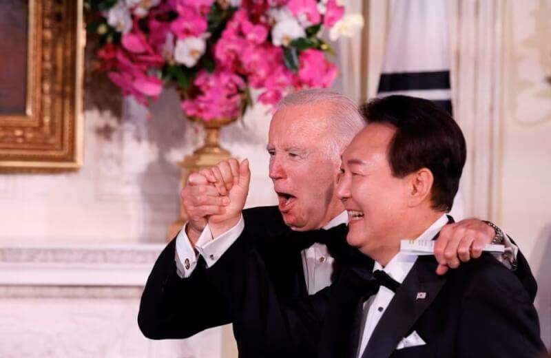 美國總統拜登（左）26日在白宮舉行晚宴，宴請韓國總統尹錫悅（右）夫婦，兩人高歌同樂。（路透社）