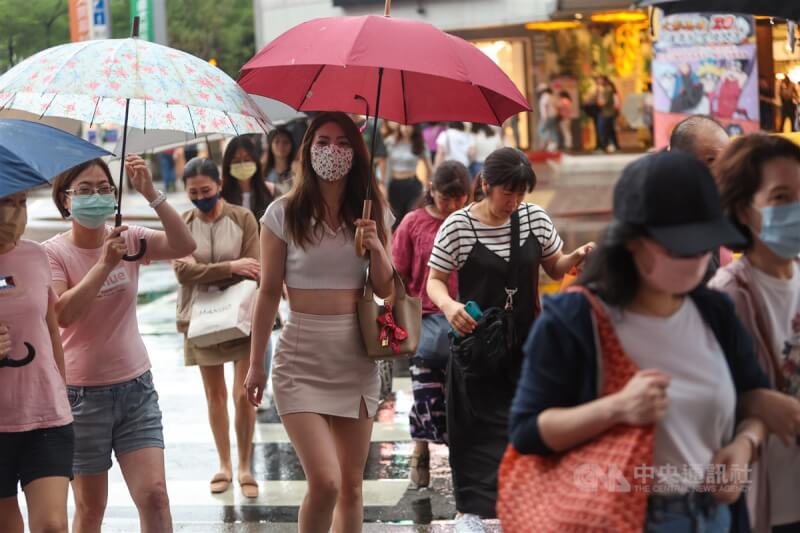 氣象局預估29日晚上到30日白天，中部以北及東部地區容易有局部降雨。圖為北市南西商圈民眾撐傘遮雨。（中央社檔案照片）