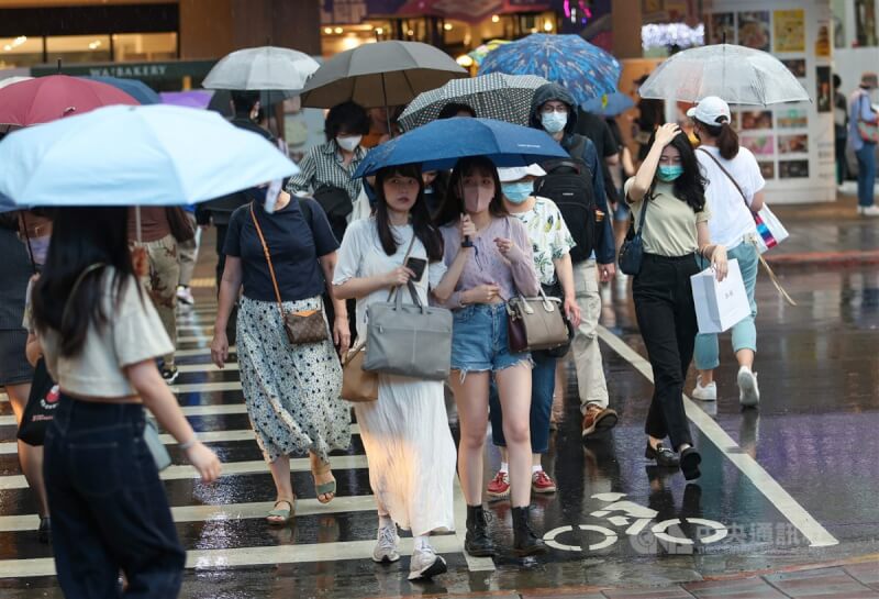 氣象局表示，29日晚間起中部以北開始出現陣雨，越往北感受較明顯。圖為台北市南西商圈逛街的民眾撐起雨傘擋雨。（中央社檔案照片）