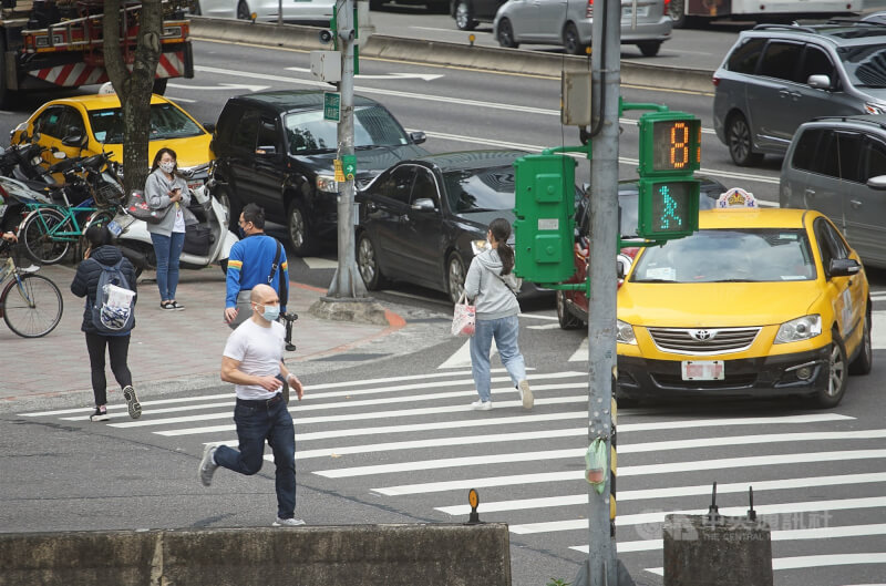 圖為北市民眾過馬路。（中央社檔案照片）