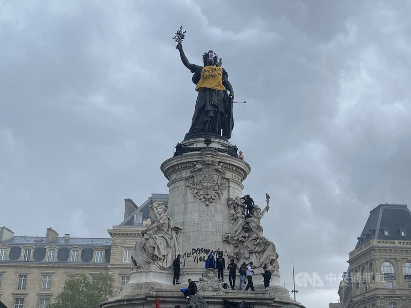 巴黎遊行2日下午從共和廣場（Place de la République）出發，一到廣場便可見警察與憲兵全副武裝，爆炸聲此起彼落，更有人綁上繩索攀爬到雕像頂端，替雕像穿上「馬克宏下台」的黃背心，引起全場掌聲。中央社記者曾婷瑄巴黎攝 112年5月2日