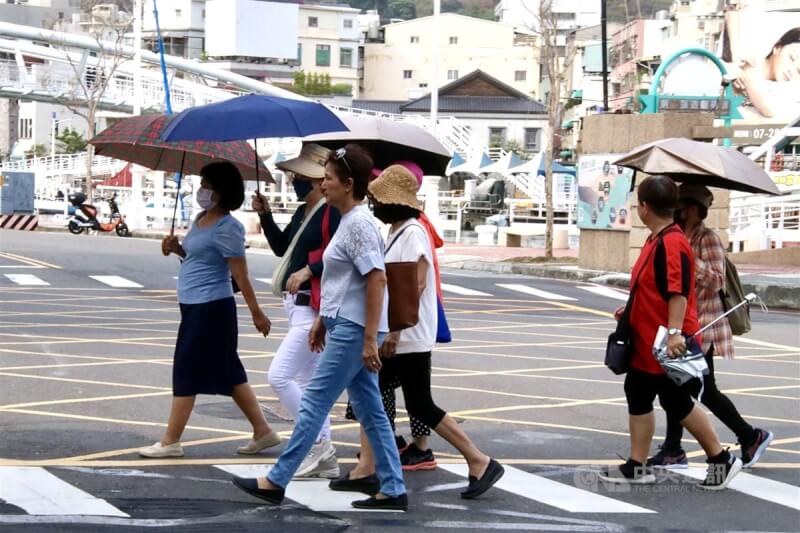圖為高雄鼓山區街上部分民眾外出撐傘遮陽。（中央社檔案照片）