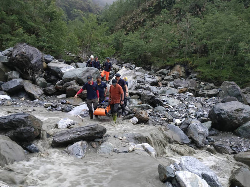 一行5人登山隊伍走馬博橫斷路線，3日行經中平林道28公里處時，55歲張姓女山友不慎滑落8公尺深邊坡，頭、腳受傷無法行走，因天氣不佳無法吊掛，地面搜救隊伍協力將她搬抬下山。（花蓮縣消防局提供）中央社記者張祈傳真  112年5月6日