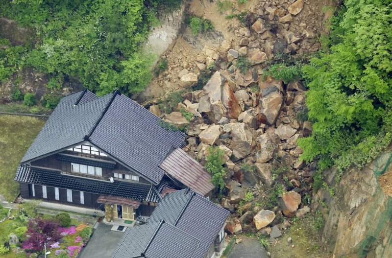 日本石川縣5日發生規模6.5地震，直升機空拍畫面可見珠洲市一處山坡地土石崩落波及房屋。（共同社）