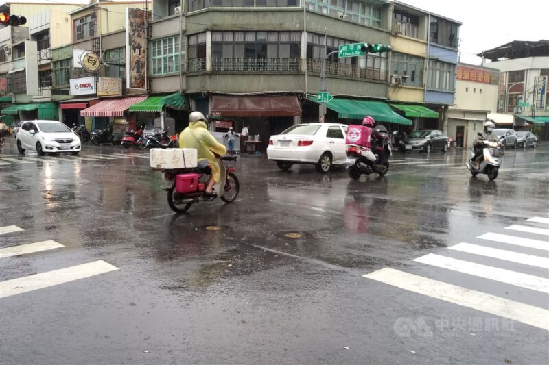 受鋒面通過影響，台南多數地區7日上午出現雨勢，鹽水區街頭的機車騎士穿上雨衣。中央社記者楊思瑞攝 112年5月7日