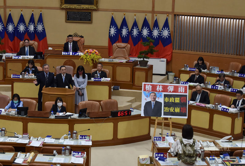 民進黨新北市議員戴瑋姍（前右）等11日穿防彈衣在新北市議會質詢，指新北已成新「慶記之都」，但新北市長侯友宜（2排左2）說，新北治安穩定，不是槍林彈雨，「個案發生個案解決」，新北發生案件，他與新北市政府警察局長會扛起責任，把歹徒繩之以法。中央社記者高華謙攝  112年5月11日