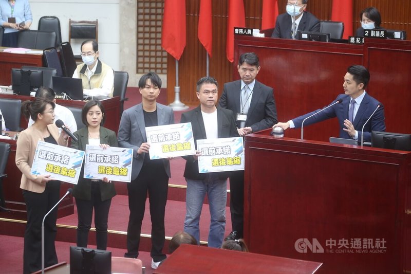 台北市長蔣萬安(前右)15日前往台北市議會進行專案報告並列席備詢,民眾黨台北市議員林珍羽(前左起)、黃瀞瑩、陳宥丞與張志豪要求蔣萬安簽署「興建社會住宅承諾書」,並舉牌喊「選前承諾、選後龜縮」。中央社記者趙世勳攝 112年5月15日