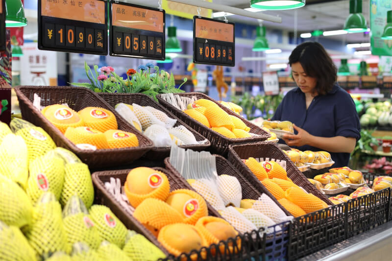 圖為11日中國山東省民眾在一家超市選購水果。（中新社）