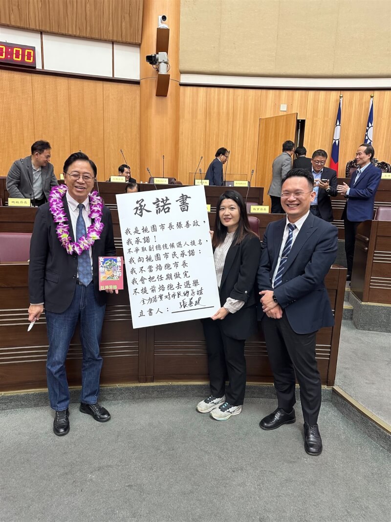 桃園市長張善政（前左）18日在桃園市議會備詢時，簽下由民進黨議員魏筠（前右2）製作的「不當落跑市長」承諾書，也不爭取副總統候選人提名。（魏筠提供）中央社記者葉臻傳真 112年5月18日