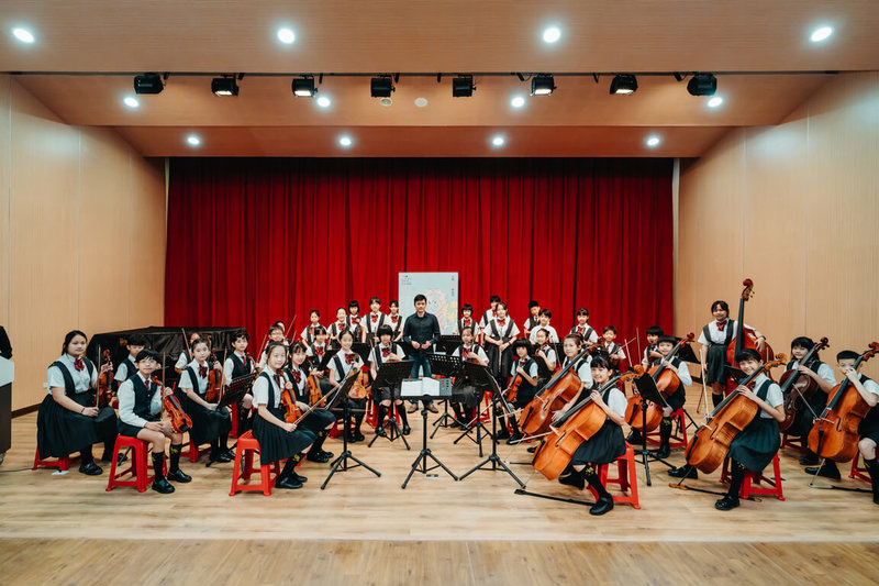 國家交響樂團（NSO）將在台南舉辦孟德爾頌講座音樂會，規劃音樂會的貝桑頌國際指揮大賽冠軍吳曜宇（中立者）18日受邀為永福國小管弦樂團上課，學生收穫滿滿。（NSO國家交響樂團提供） 中央社記者趙靜瑜傳真  112年5月19日