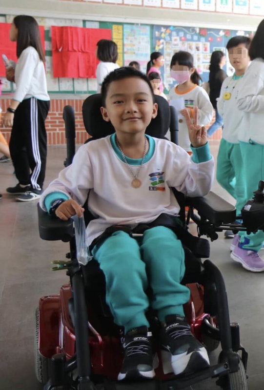 2023年總統教育獎名單19日公布,高雄市王功國小學生潘博均(前)獲獎。他罹患先天性脊柱裂及水腦,無法自主行動,但他個性樂觀,利用下課時間練習職能物理治療師建議的自主訓練,即使坐在輪椅上,體育課也和同學一起做伸展操、丟球,曾登上教育部「一起。愛上體育課」微電影。(教育部提供)中央社記者陳至中台北傳真 112年5月19日
