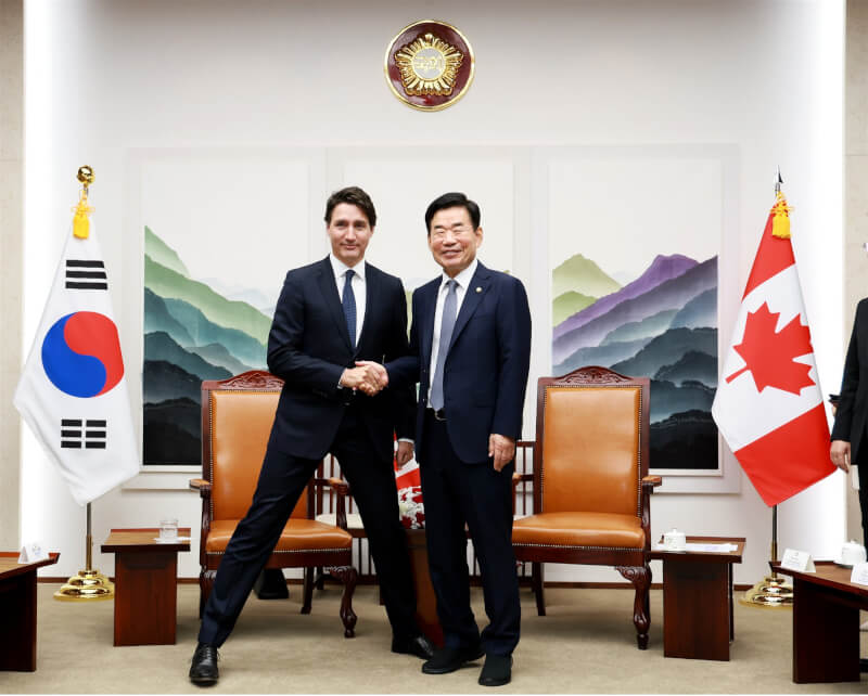 加拿大總理杜魯道（左）近日與韓國國會議長金振杓合照時，為了配合對方身高劈開雙腿，擺出「禮儀腿」姿勢。（圖取自twitter.com/news_NA）