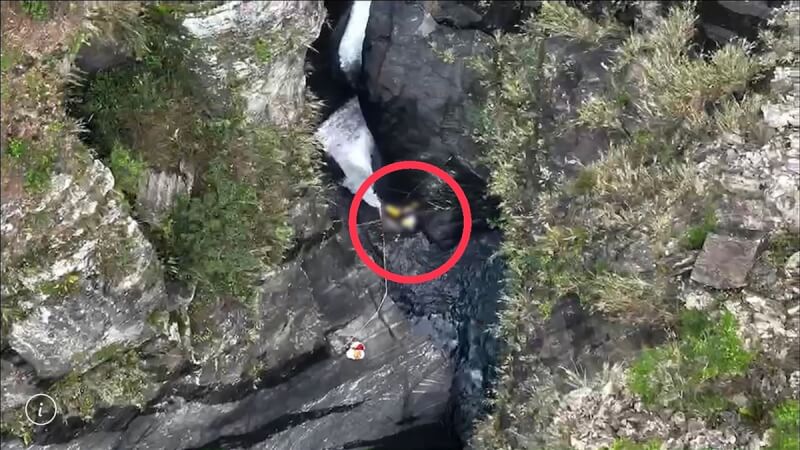 屏東飛龍瀑布溯溪團意外，救難人員21日下午發現一名吊勾在岩壁上的女性遺體（紅圈處）。（屏東縣消防局提供）中央社記者李卉婷傳真 112年5月21日