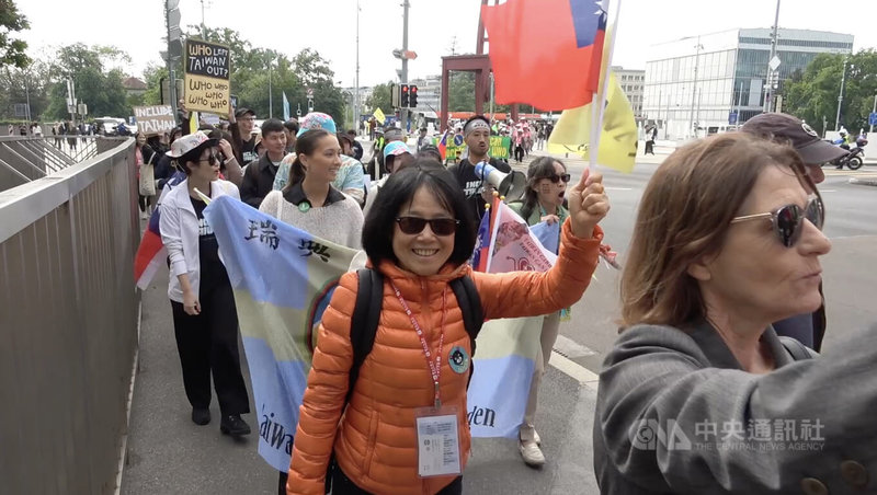 世界衛生大會（WHA）將於21日開議，近500名台僑、民團與國際友人20日齊聚日內瓦聯合國三角椅廣場，出發遊行，約一個半小時，一旁車輛也鳴按喇叭予以支持。中央社記者曾婷瑄日內瓦攝  112年5月21日