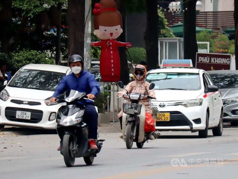 越南多地5月就出現攝氏40度以上高溫，越南官方警告缺電危機。圖為越南民眾在豔陽下全身包緊緊騎機車，深怕曝晒。中央社記者陳家倫河內攝  112年5月23日