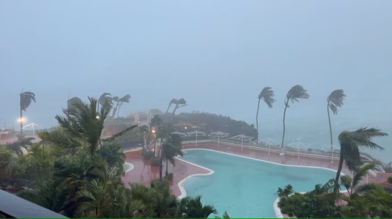 颱風瑪娃侵襲關島，樹木在強風中左右搖擺。（翻攝畫面／路透社）