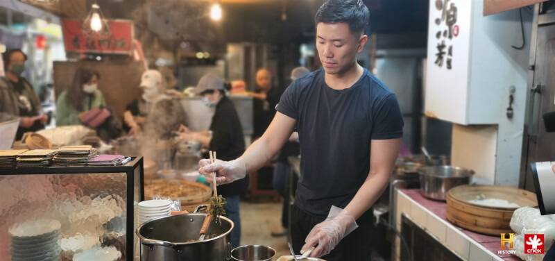 紀實節目「我的台灣味」主持人、在美國紐約經營台菜餐廳的台裔老闆克里斯余（Chris Yu）重返台灣，參訪必比登小吃「源芳刈包」並親自嘗試包料。（杰德影音提供）中央社記者葉冠吟傳真 112年5月25日