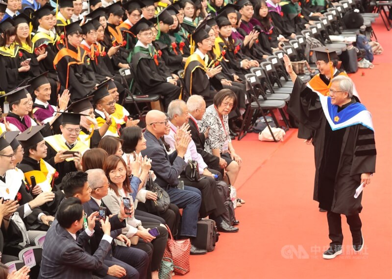 國立台灣大學27日舉辦畢業典禮，邀請身價逾新台幣1兆元、有「AI教父」之稱的的輝達（NVIDIA）執行長黃仁勳（前右）致詞，黃仁勳離場時，向台大畢業生揮手致意。中央社記者張新偉攝　112年5月27日