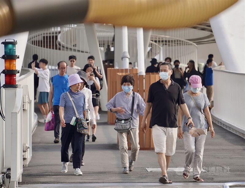 圖為高雄大港橋周邊有許多民眾出遊，不少人仍維持戴口罩。（中央社檔案照片）