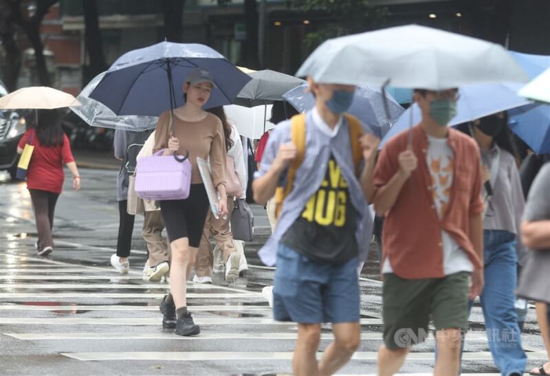 5月31日受颱風瑪娃外圍環流影響及午後對流雲系發展旺盛，台北市出現雨勢，大安區民眾撐傘過馬路。中央社記者張新偉攝 112年5月31日