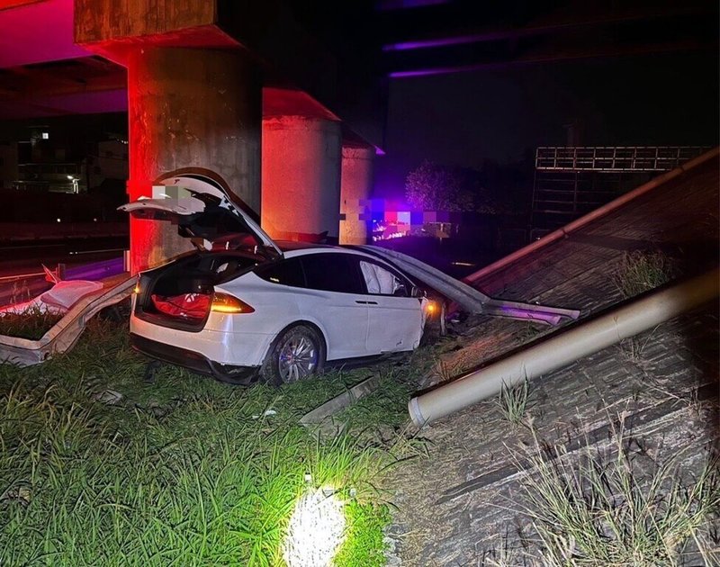 國道1號南下嘉義路段1日發生特斯拉電動車撞上護欄衝出邊坡事故,車上2人受傷送醫;警方調查,25歲駕駛疑因開啟「輔助駕駛系統」操作不當撞上護欄。(警方提供)中央社記者黃國芳傳真 112年6月1日