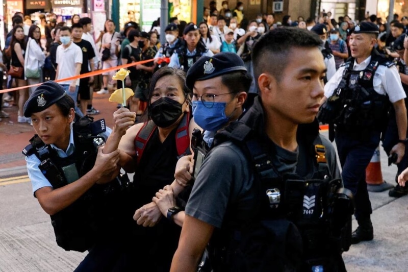圖為4日香港警方逮捕一名手持紙花的民眾。（路透社）