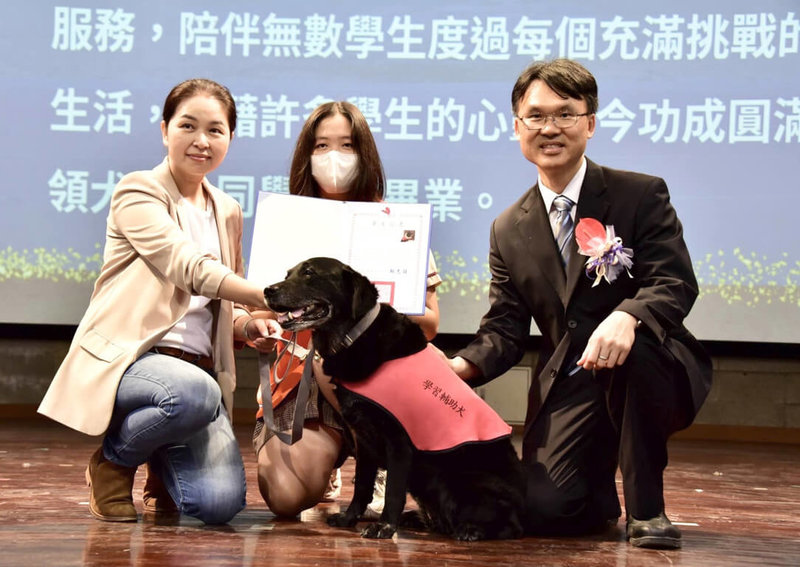 高雄市明華國中6日頒發畢業證書給學習輔助犬Pretty，在領犬員學生余承蕙（中）陪同下，Pretty與校長鄭志昇（右）合影。（明華國中提供）中央社記者林巧璉傳真 112年6月6日