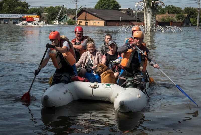 圖為7日救難人員從洪水氾濫的赫松地區疏散居民。（路透社）