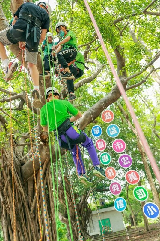 高雄市大寮區忠義國小6日在樹上舉行畢業典禮,畢業生須攀上10公尺高的大樹,在樹上接過校長陳建利頒發的畢業證書,象徵克服困難,迎向人生挑戰。(忠義國小提供)中央社記者林巧璉傳真 112年6月7日