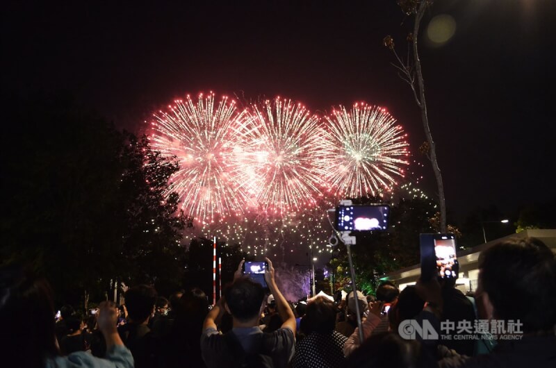 今年國慶焰火將在台中中央公園施放。圖為去年民眾在嘉義故宮南院外高舉手機，搶拍國慶焰火。（中央社檔案照片）
