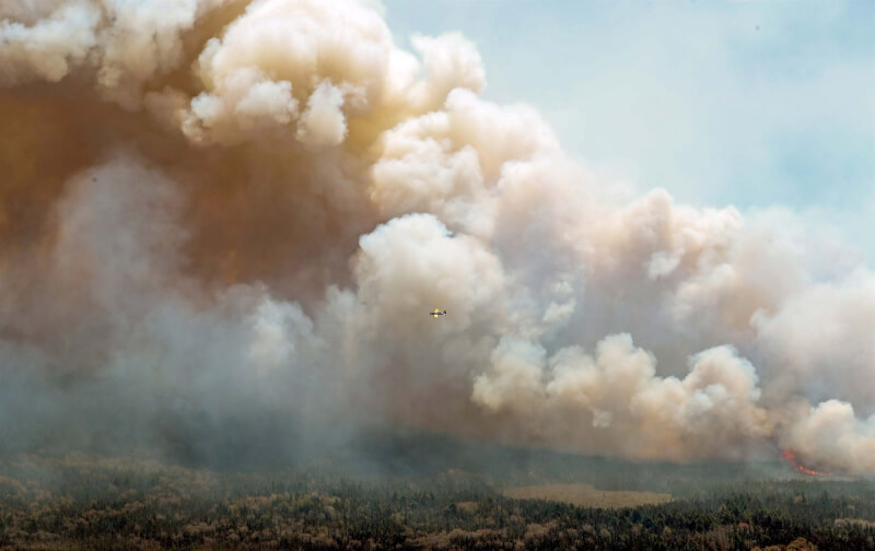 加拿大森林大火蔓延，1日新布朗斯威克省一架飛機從空中灑下水和阻燃劑。（圖取自facebook.com/nsgov）